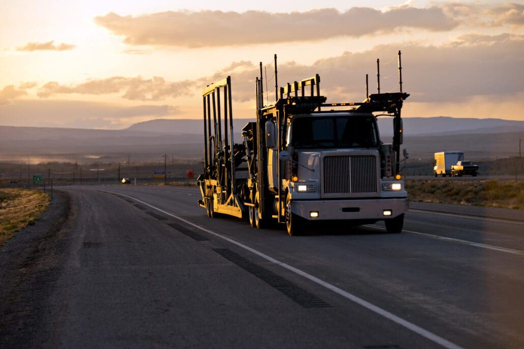 Car hauler semi truck on the road in sunset