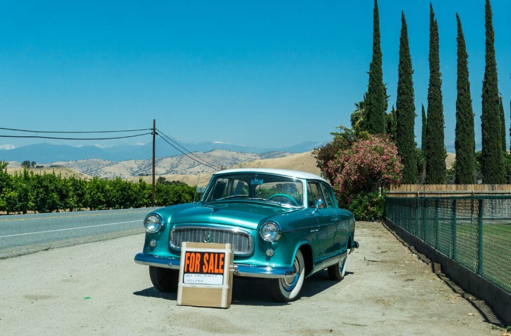 Three Rivers, California, USA - June 15, 2017: Roadside and old retro car put up for sale. Picturesque highway in the countryside in California, USA, and selling an old car. Road to the Sequoia National Park.
